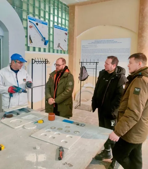 Андрій (другий ліворуч) з викладачем та учасниками у навчальному просторі